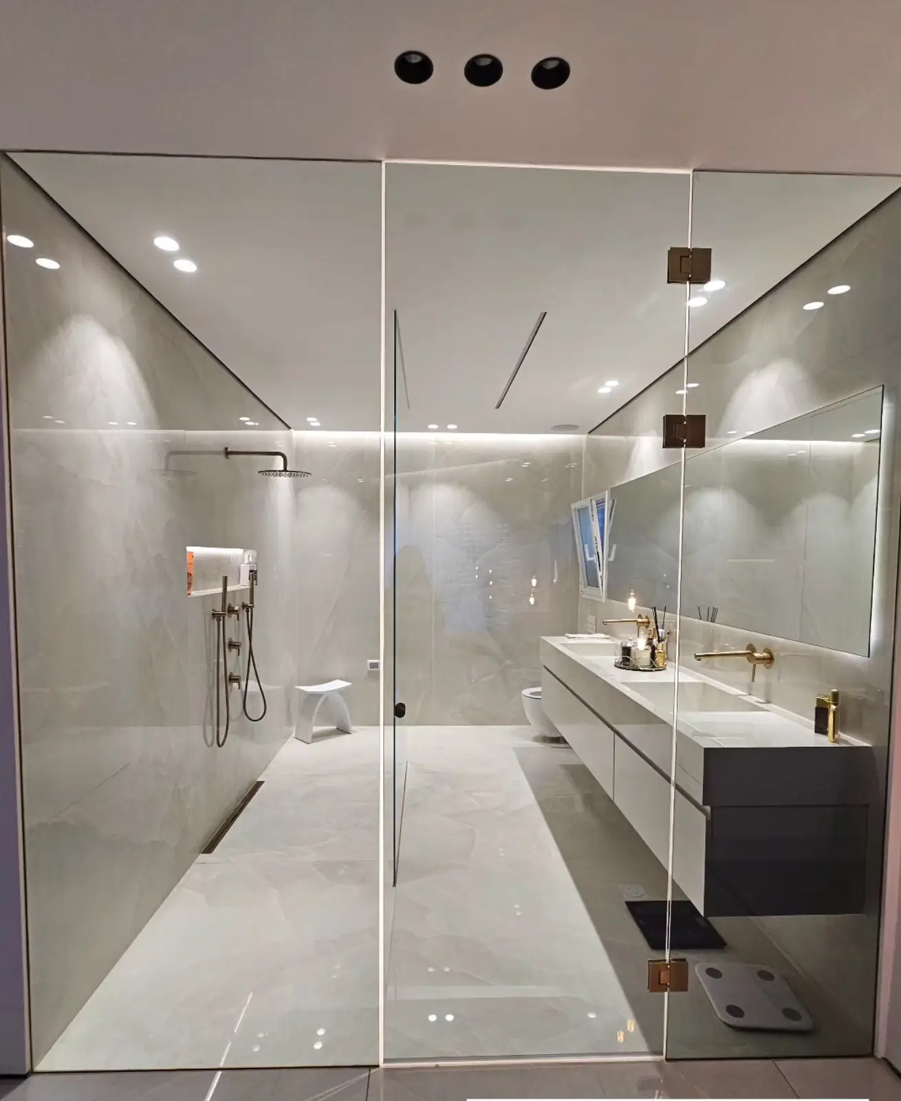 חדר רחצה יוקרתי עם מקלחון זכוכית וברזים זהב